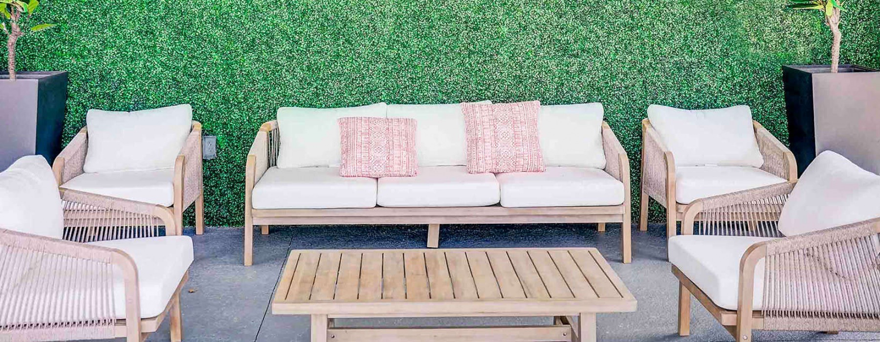 outdoor patio with furnishings in front of a plant covered wall
