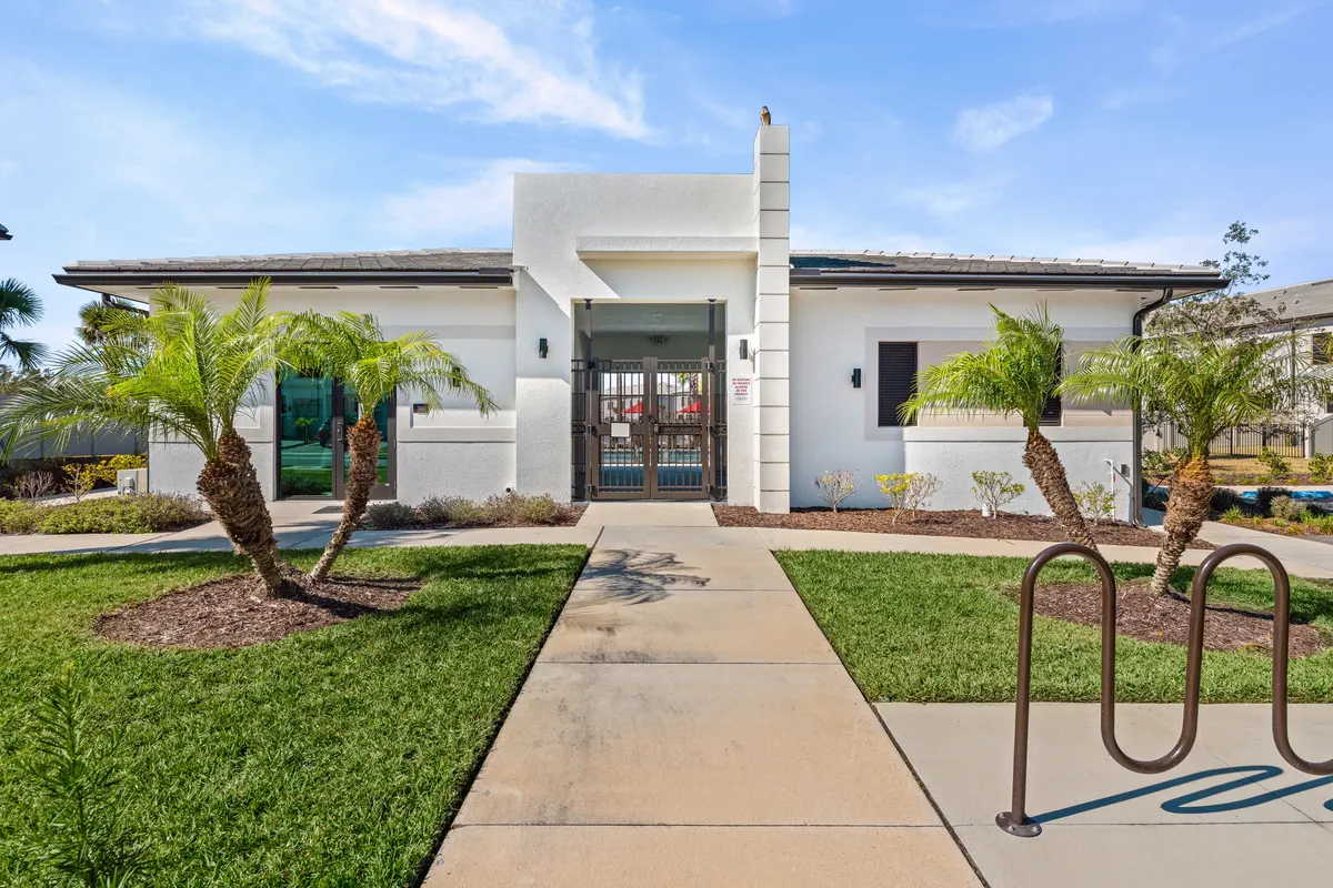 Clubhouse exterior with palms and a bike rack