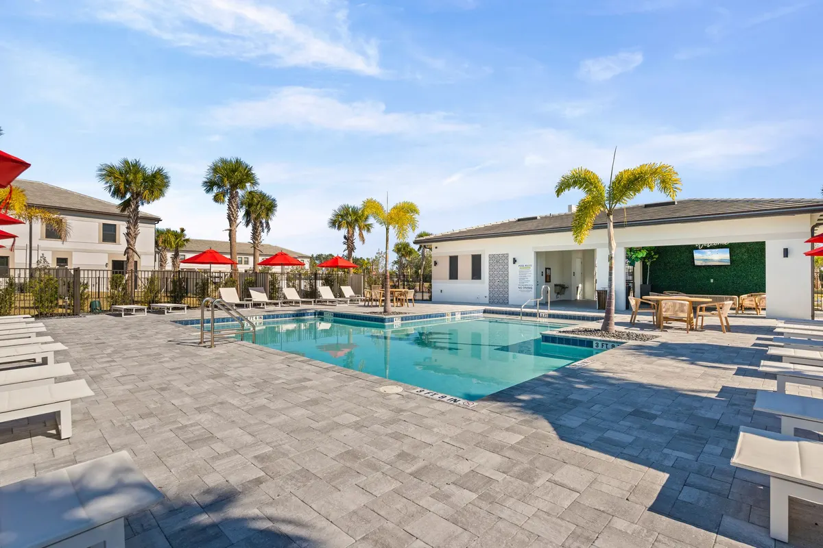 Wide view of the pool and deck with townhomes behind