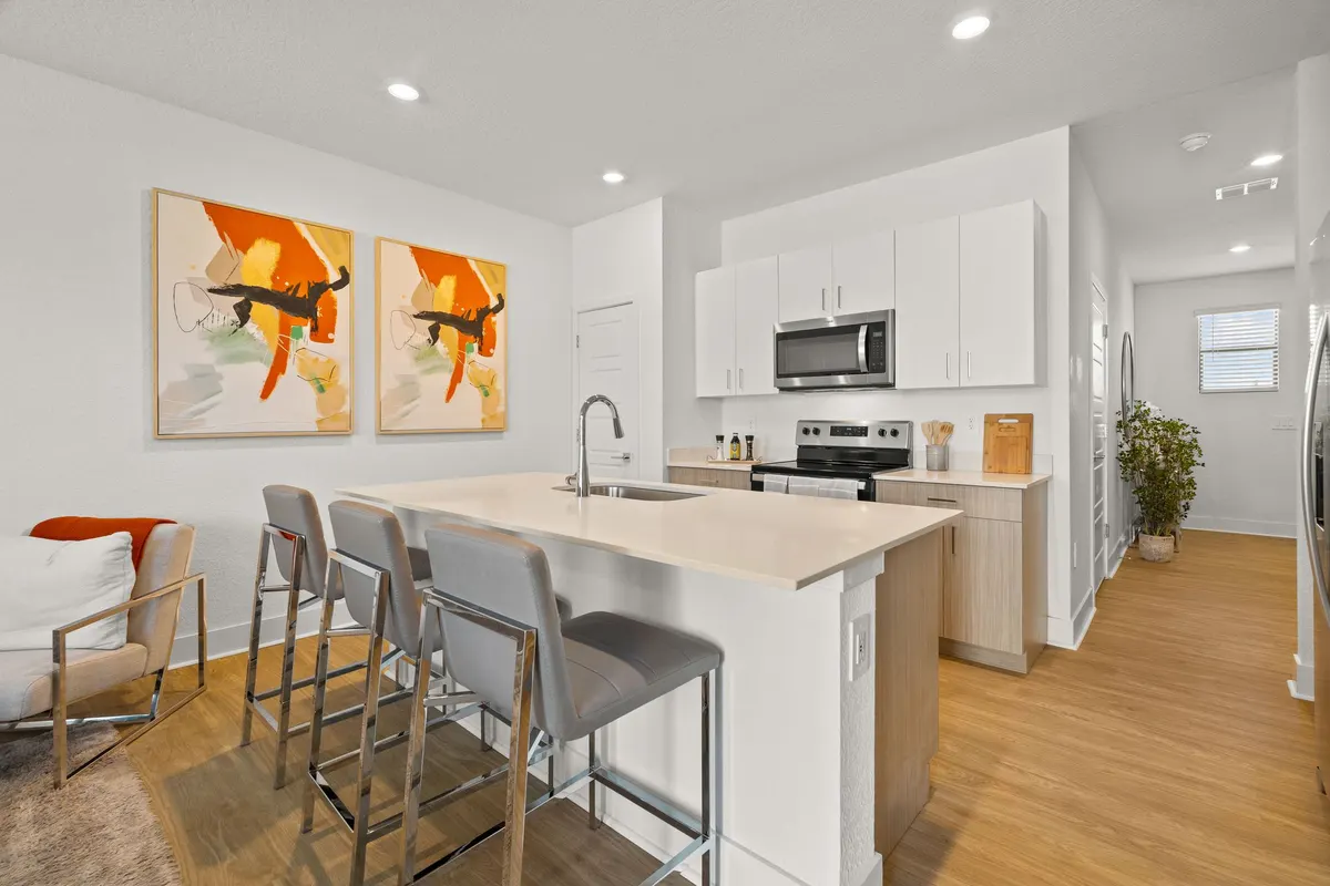 Kitchen island with bar stools and stainless appliances